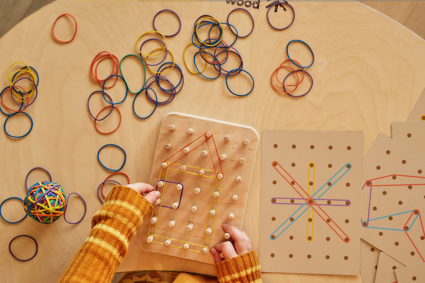 WOODEN GEOPLAN MONTESSORI- GOOD WOOD CHILD MAKING A HOUSE SHAPE ON THE NATURAL GEOPLAN