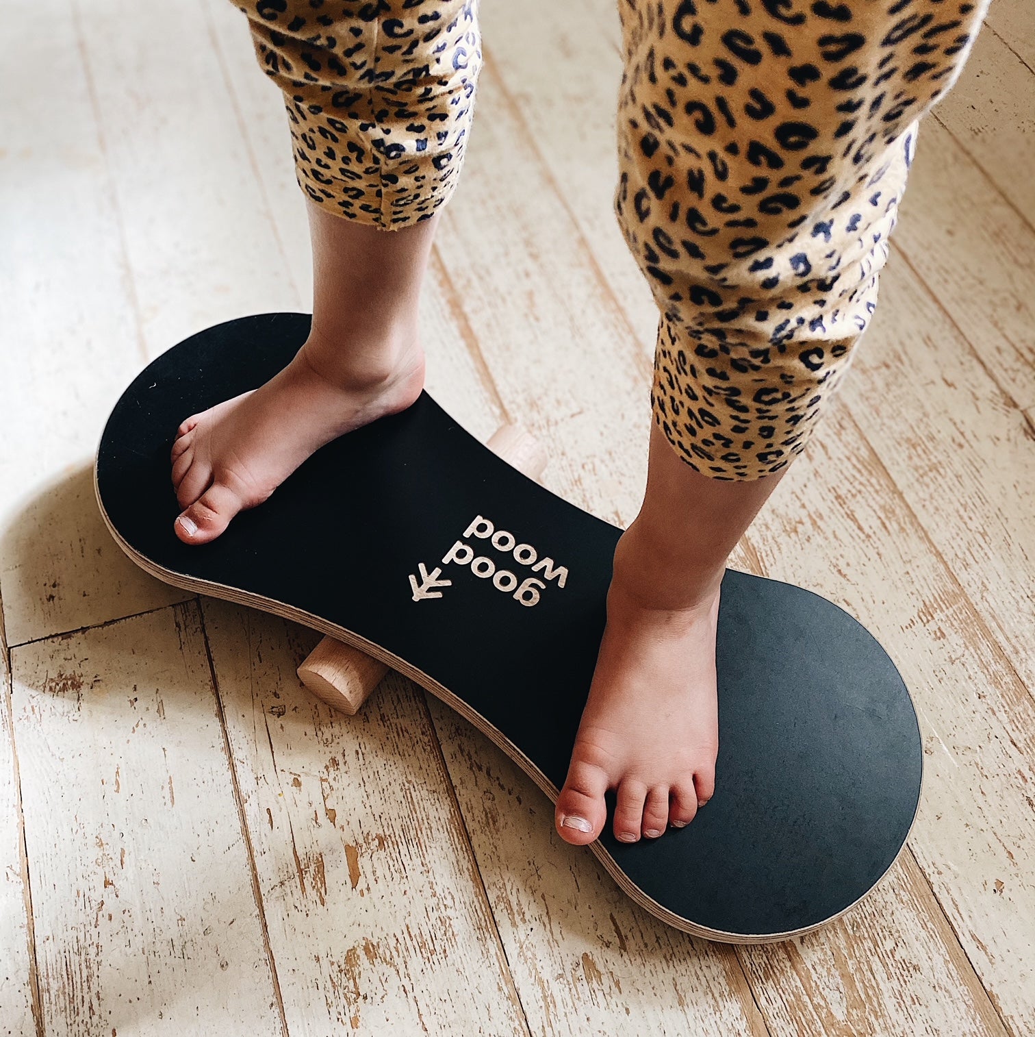 A GIRL BALANCING ON THE BLACK BALANCE BOARD / TRICK BOARD FOR KIDS- GOOD WOOD